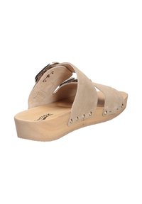 Beige suede sandal with two cross straps, wooden platform sole, and metal accents. Features decorative rivets along the side.