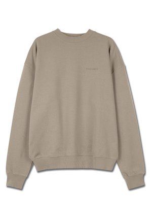 Bēša krekls ar apaļu izgriezumu, ribotas aproces un apakšmalu. Rotāts ar izšuvumiem uz krūtīm. Izgatavots no maiga, teksturēta auduma.