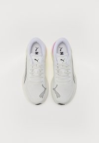 Witte sport sneakers van mesh materiaal, met zwarte accenten en een licht roze-paarse gradient op de hak. Puma-logo zichtbaar op de zijkanten en de tong.