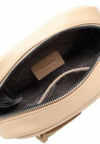 Light beige leather bag with a textured finish, zip closure, and a gray patterned interior featuring a card pocket and a subtle label.