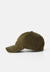 Casquette de baseball en velours côtelé olive avec une visière courbée et un tissu texturé, arborant un petit logo sur le devant.