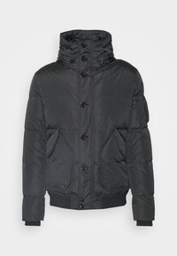 Svart puffjacka med hög krage, med knappstängning, två sidofickor och ribbade ärmslut. Slät, glänsande textur.