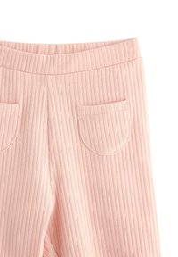 Vaaleanpunaiset ribbileggingsit, joissa on leveä vyötärönauha, kaksi pientä päällyspokkia ja ommeltu yksityiskohtia reunoilla. Pehmeä, joustava materiaali.