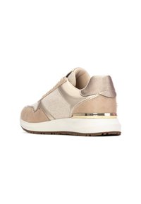 Zapatillas beige que presentan una combinación de materiales de ante y malla, detalles metálicos, un talón acolchado y una suela texturizada.