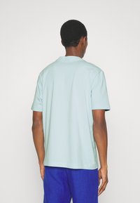 Ljusblå bomullströja med korta ärmar och rundad halsringning, med en avslappnad passform och ren, enkel design. Inga synliga mönster.