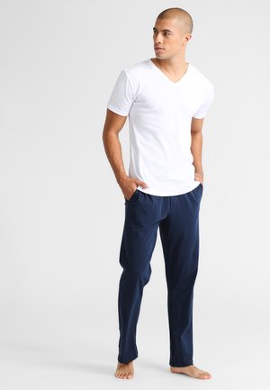 White V-neck T-shirt, paired with navy blue, loose-fitting pants. Soft fabric, minimal design, with an elastic waistband and no visible patterns.