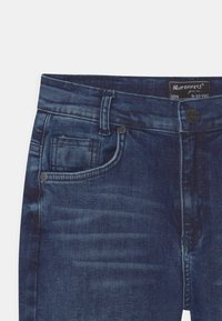 Granatowe dżinsy z klasycznym pięciopocketowym wzorem, z metalowym zapięciem i subtelnymi detalami w kolorze wyblakłym. Rozmiar 9-10 lat.