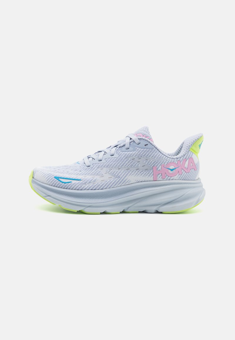 Scarpe sportive azzurro chiaro con tomaia in rete, suola bianca e accenti giallo-verde vivaci. Presentano un logo rosa laterale.