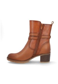 Bota de tobillo de cuero marrón claro con cremallera lateral, detalle de correa, tacón bloque y lengüeta en la parte trasera.