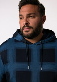 Felpa navy blu con motivo a quadri, caratterizzata da linee azzurre a contrasto e cappuccio con cordino. Tessuto morbido, design casual.