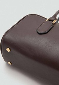 Geantă maro din piele sintetică, cu formă curbată, accesorii aurii și suprafață texturată, prevăzută cu piciorușe metalice de protecție la bază.