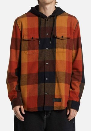 Camisa de franela con un patrón a cuadros en naranja, rojo y negro. Diseño abotonado con dos bolsillos en el pecho y capucha negra adjunta.
