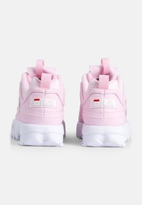 Zapatillas deportivas rosas con parte superior sintética texturizada, lengüetas de tirón en la parte posterior, cuello acolchado y suelas de goma blanca con un patrón de olas.