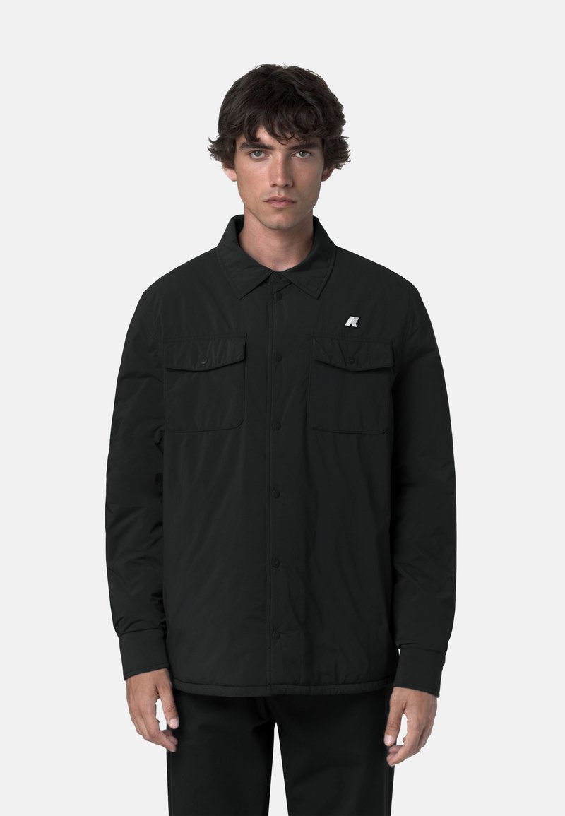 Giacca nera con bottoni realizzata in tessuto leggero. Presenta due tasche sul petto, maniche lunghe e un piccolo logo sul lato sinistro.