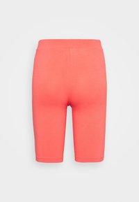 Korálově zbarvené cyklistické šortky s vysokým pasem a délkově ke kolenům, zobrazené zezadu na bílém pozadí.