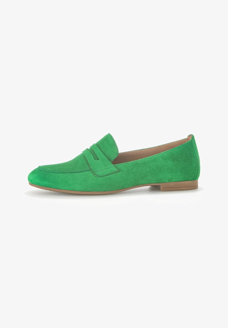 Mocassin plat en daim vert avec détail de bride à bouton-poussoir et semelle beige, présenté de profil sur fond blanc.