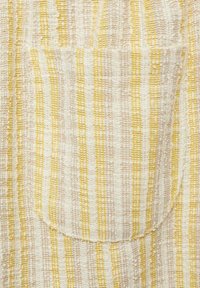 Textured fabric with vertical lines in pale yellow and soft pink. Features a front pocket with a rounded top edge.