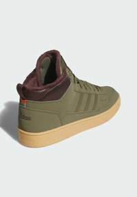 High-top sneaker in olive green with brown accents, textured surface, cushioned collar, and rubber sole with light gum color. Three stripes design.