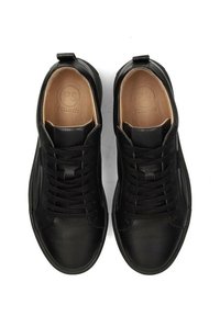 Baskets en cuir noir avec une finition texturée, présentant un design à lacets, un bout arrondi et un logo embossé sur la semelle intérieure.