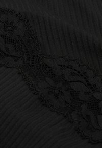 Textil negro con textura acanalada vertical, complementado con un detalle de encaje en un patrón floral a lo largo de un borde.
