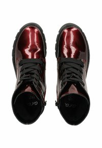 Bottines montantes en matériau synthétique bordeaux brillant, ornées de lacets noirs, de coutures contrastées et d'une fermeture éclair sur le côté.