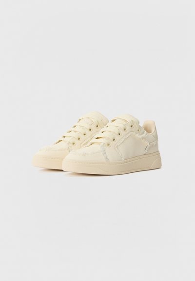 Beige lærreds sneakers med rund tå, syede detaljer og teksturerede accenter. Snørebåndsdesign og flad gummisål.