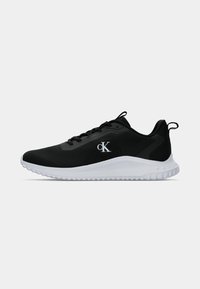 Baskets de sport noires avec semelle blanche, lacets noirs et logo blanc "cK" sur le côté, affichées de profil droit sur fond uni.