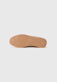 Suola in gomma con motivo a nido d'ape, di colore beige e bordo arrotondato. Presenta grip esagonali sollevati per una migliore aderenza.