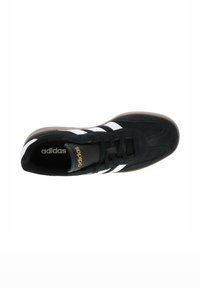 Sneaker in suede nero con strisce bianche, suola in gomma, colletto imbottito e branding dorato. Presenta una superficie texturizzata per una presa e un supporto ottimali.