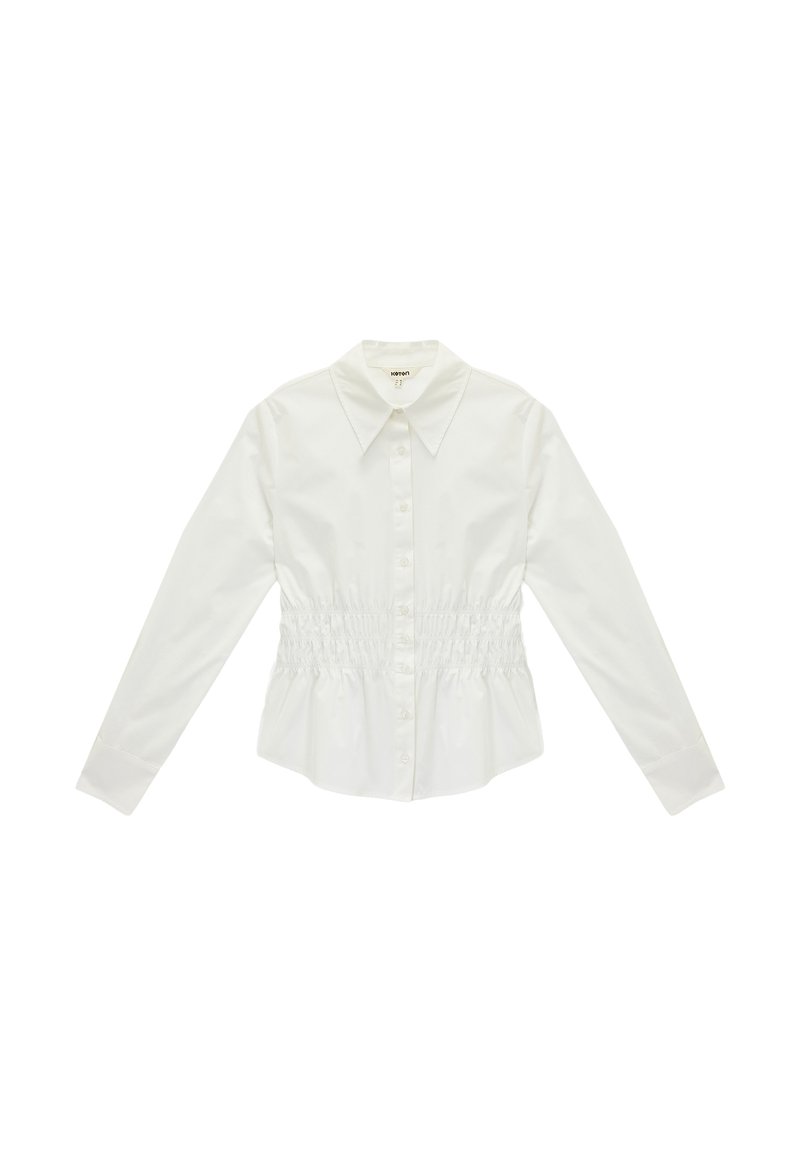 Camisa blanca de botones con mangas largas, presenta un cuello clásico y cintura fruncida para una forma ajustada. Hecha de tela suave y ligera.