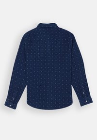Camicia a maniche lunghe di un blu navy scuro con motivo bianco. Presenta un colletto, polsini abbottonati e un orlo arrotondato. Tessuto morbido e testurizzato.