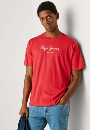 Rdeča bombažna majica s kratkimi rokavi in klasičnim okroglim izrezom, na sprednji strani pa ima bel napis "Pepe Jeans London".