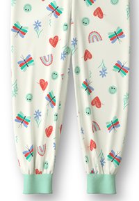 Crème-kleurige broek met een speels patroon van vlinders, harten, bloemen en lachende gezichten. Opgerolde enkels met mintgroene ribbel.