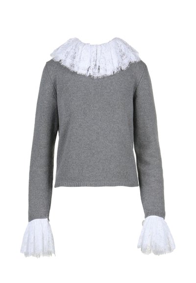 Pilkas megztinis su baltu nėriniu aptrauktu apykakle ir nėriniu išplėstais rankovėmis. Turi trumpą krokuotą siluetą ir banguotą hemą.