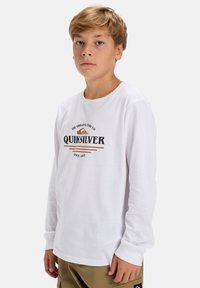 Witte lange mouwen t-shirt met het "Quiksilver" logo in zwart en bruin, ronde hals, ribgebreide manchetten en een zachte katoenen textuur.