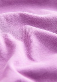 Zachte, lichtpaarse, gebreide stof met zichtbare textuur en zachte plooien die subtiele schaduwen en highlights creëren.