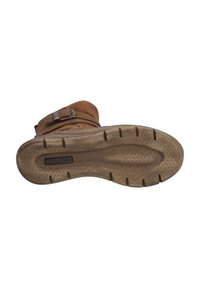 Brown suede ankle boot with a textured rubber sole, featuring a decorative strap and buckle detail. Sole has a patterned tread for grip.
