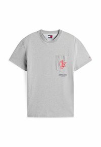Camiseta gris de manga corta hecha de algodón. Presenta un bolsillo en el pecho con un logo en rojo y texto. Cuello redondo clásico. Textura suave.