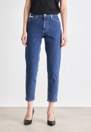 Vaqueros de mezclilla azul con cintura alta, piernas rectas y longitud recortada. Presentan costuras clásicas y cierre de botón en la parte delantera.