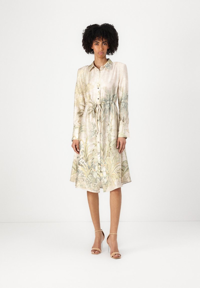 Abito camicia in satin con stampa floreale e palme in toni di verde e beige tenui, con chiusura a bottoni, vita con fiocco e maniche lunghe.
