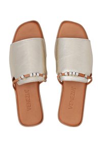 Flade sandaler med en overdel i gyldent metallisk læder og en sål i brun læder. Har en rem med dekorative sølv detaljer. Firkantet tå-design.