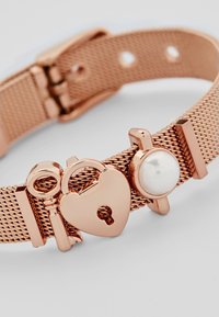 Bracciale in mesh color oro rosa con un lucchetto a forma di cuore, una chiave e un accento di perla rotonda. Texture liscia con dettagli in metallo lucido.