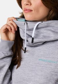 Felpa grigia con colletto alto, lacci bianchi e logo teal; presenta una texture con un sottile motivo melange.