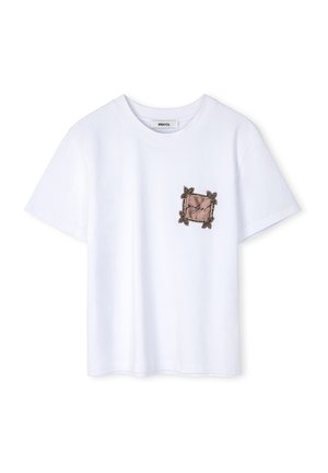 T-shirt en coton blanc avec un petit patch décoratif à cadre marron et un texte manuscrit, accentué par des embellissements autour des bords.