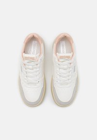 Zapatillas blancas con acentos rosas, materiales de cuero y ante, punta redondeada, cuello acolchado y suela de goma texturizada. Cierre con cordones en estilo clásico.
