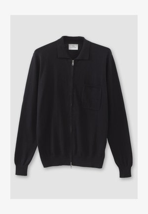 Schwarze Reißverschluss-Strickjacke mit flachem Kragen, langen Ärmeln und einer einzelnen Brusttasche. Hergestellt aus einem weichen, strukturierten Stoff.