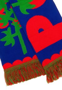 Wełniany szalik z wyraźnym niebieskim tłem, zdobionym dużymi geometrycznymi wzorami w kolorze czerwonym i zielonym, wykończony wielokolorowymi frędzlami na brzegach.