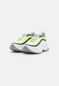 Sneakers bianchi chunky con accenti verde neon e grigio scuro, tessuto texturizzato, tomaia in mesh, suola in gomma spessa e lacci riflettenti.