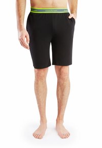 Czarne bawełniane szorty z bocznymi kieszeniami i zielonym paskiem z napisem "slopes & town". Długość do połowy uda, gładka tekstura.