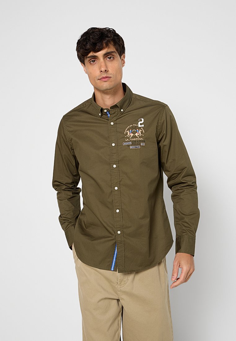 Camicia verde oliva a maniche lunghe con colletto button-down, ricami in evidenza e polsini interni a fantasia. Realizzata in cotone.